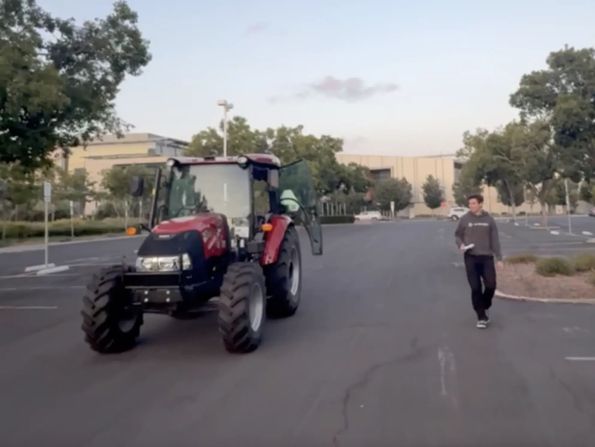 Tractor without a driver driving in a parking lot.