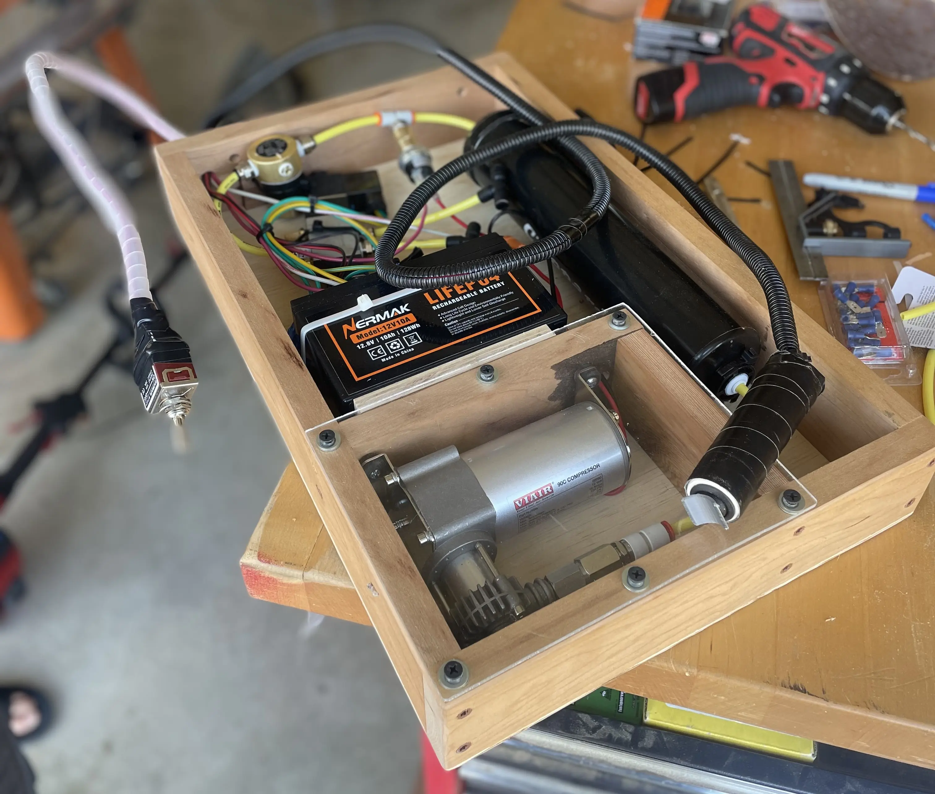 Wood frame with air compressor, tank, and pneumatic tubing